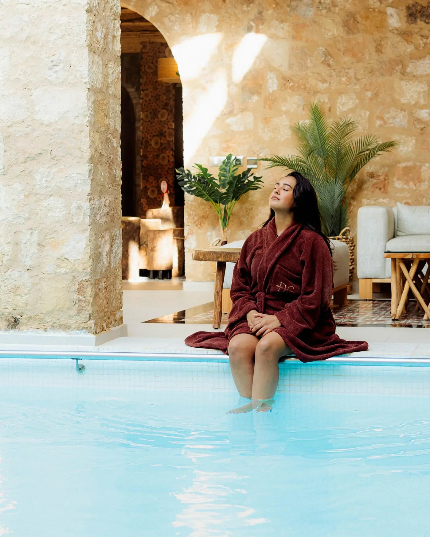 Une curiste en peignoir DC, assise au bord de la piscine thermale